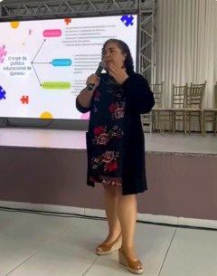 Monica Dias palestrando com microfone